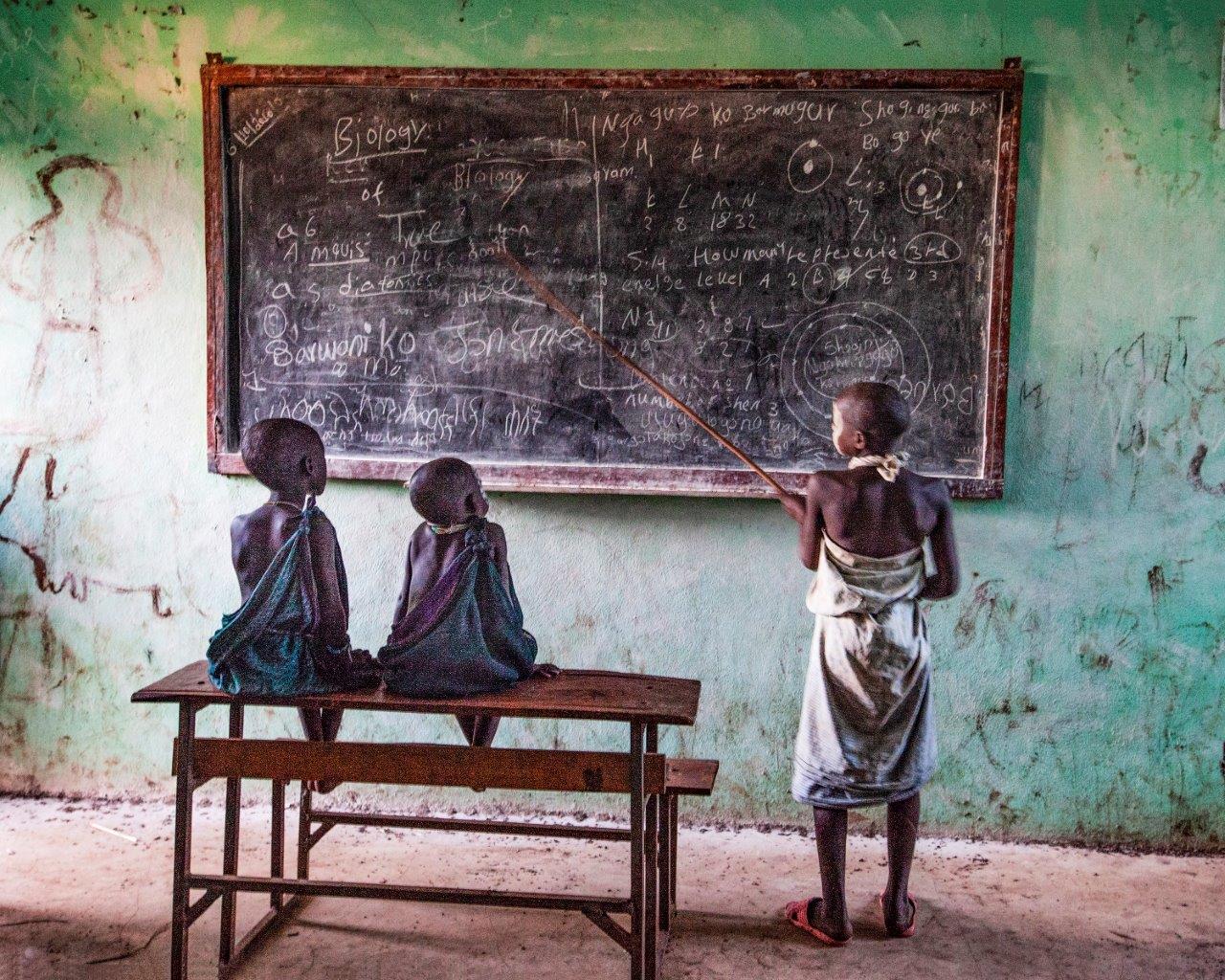 Zdjęcie konkursowe z wystawy pod tytułem Dziecko - Trójka dzieci przy szkolnej tablicy